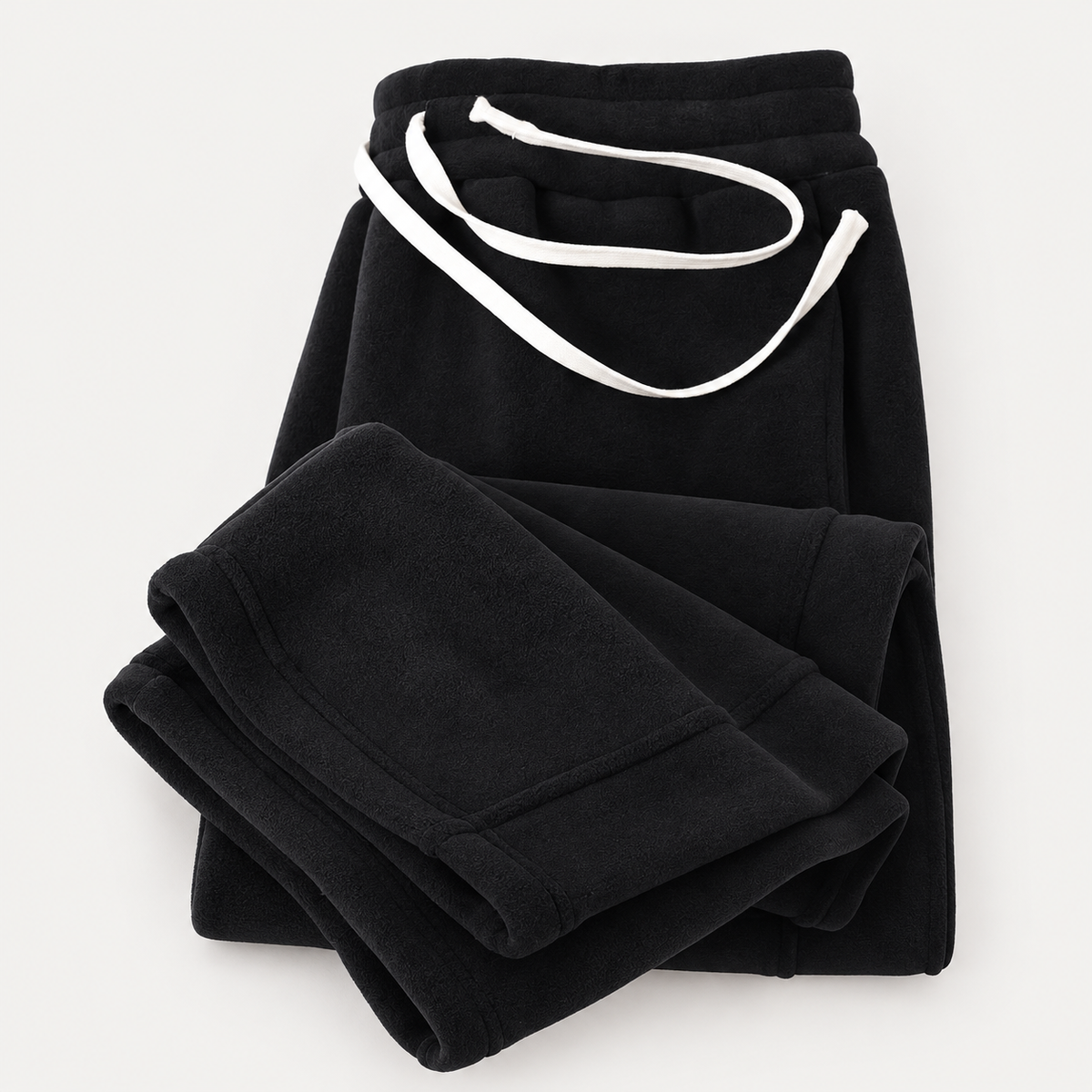 FleeceFlow Relaxed Trousers in Black on a warm light-grey studio background